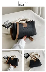 Detail of black chevron quilted tote bag with brown handles and adjustable shoulder strap