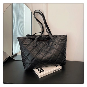Close-up of black quilted leather tote bag with elegant diamond stitching pattern