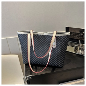 Detail of grey geometric pattern tote bag with contrasting red edge straps and large capacity