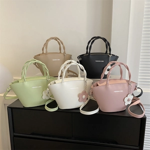 Minimalist bucket bags with woven handles and flower charms in five various solid colors