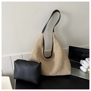 Détail du sac cabas en paille tissée avec bandoulière en cuir noir et pochette