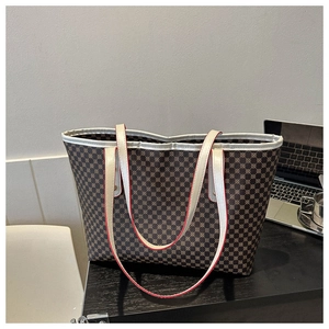 Detail view of coffee tote bag with beige circular patterns and white leather handles