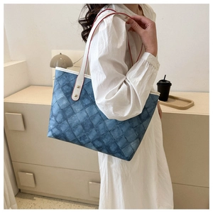 Sac cabas à motif en treillis bleu avec bandoulières blanches et bords rouges porté