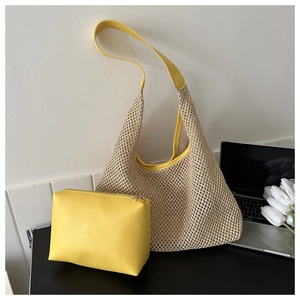 Détail d'un sac hobo en paille tressée avec garniture en cuir jaune et pochette zippée