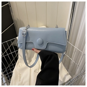 Detail of light blue rectangle baguette bag with large circular buckle and silver hardware