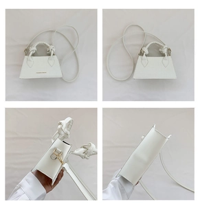 Vue détaillée du sac blanc motif crocodile avec poignée nouée et logo doré
