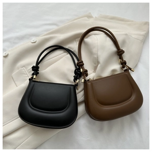 Detail of quilted leather handbags in black and brown with knotted shoulder straps