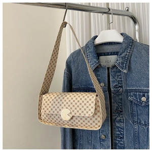 Détail d'un sac à bandoulière vintage beige avec imprimé géométrique et fermoir doré