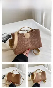 Detailed macro view of dark brown snakeskin embossed leather texture on the tote bag