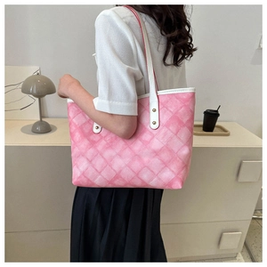 Gros plan d'un cabas à damier rose dégradé avec anses en cuir blanc et détails de rivets