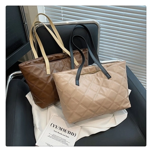 Quilted tote bags in brown and beige colors displayed on a chair with magazines