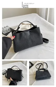 Detailed macro view of black faux snakeskin texture on elegant tote bag with silver hardware