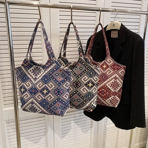 Ethnic style woven tote bag with geometric diamond patterns and long shoulder straps