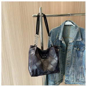Detail der schwarzen gesteppten Shopper-Tasche mit silbernen Ketten und Metallic-Textur