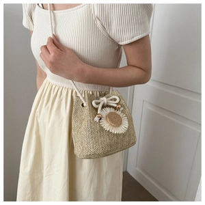 Détail du sac seau tissé à la main avec décor de marguerites et bandoulière en corde de coton