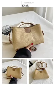 Detail of khaki tote bag with snakeskin texture and contrasting brown leather handles