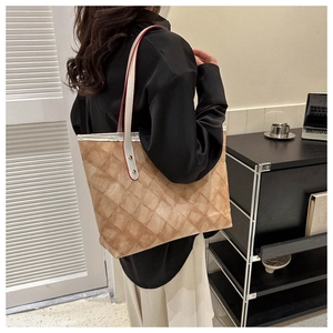 Détail du sac cabas matelassé marron montrant les rivets et les bords contrastés