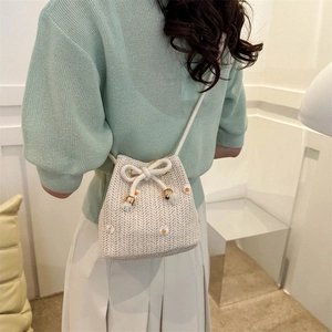 Chic beige woven drawstring bucket bag with daisy embroidery for summer fashion