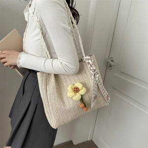 Woven straw tote bag with yellow flower and silk scarf detail for summer outings