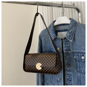 Gros plan du sac vintage marron avec imprimé géométrique et fermoir doré circulaire