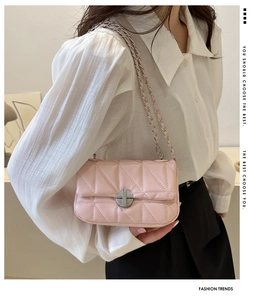 Detailed view of pink quilted PU chain bag with gold rotary lock on a white shirt