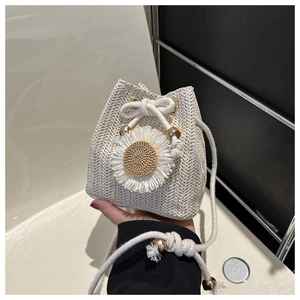 Détail du sac seau en paille tressée avec décoration tournesol et cordon de serrage