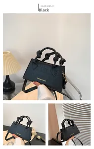 Détail de la texture cuir de crocodile noir et du logo doré embossé sur le sac
