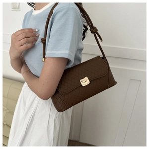 Détail du sac sous le bras tissé marron foncé avec boucle dorée et bandoulière en cuir noué