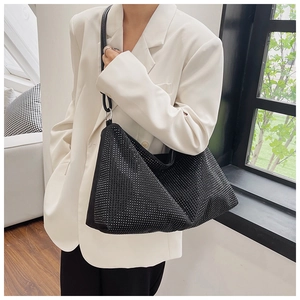Sparkling black rhinestone hobo bag worn with white blazer for a stylish look
