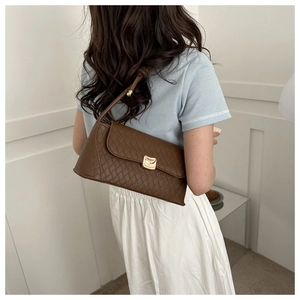 Vue arrière d'un mannequin portant le sac baguette en cuir matelassé marron à l'épaule