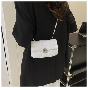 Close-up of white quilted leather crossbody bag with silver twist lock and chain strap