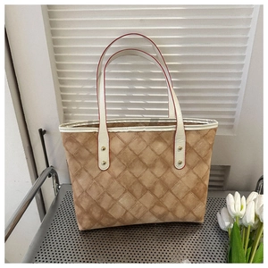 Détail du sac cabas matelassé marron avec anses blanches et bords peints en rouge