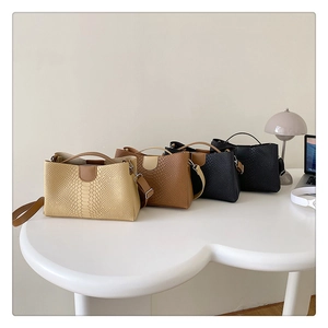 Close-up of four minimalist tote bags with embossed crocodile texture in neutral colors