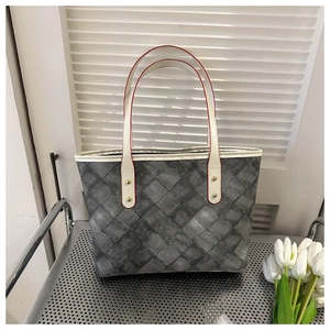 Détail du sac cabas au motif tressé Intrecciato avec anses en cuir blanc et rivets dorés