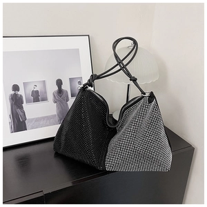 Detail of a chic rhinestone tote bag with a striking black and silver split-color design