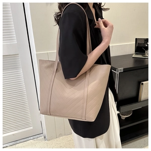 Borsa tote beige trapuntata indossata da modella mostra capienza per laptop e pendolari