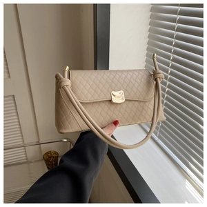 Détail du sac à bandoulière matelassé beige avec fermoir doré et nœuds décoratifs