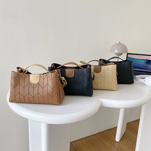 Chic women's chevron embossed tote bags in black, brown and cream on a white desk