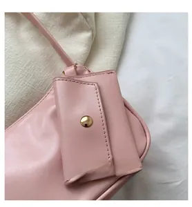 Close-up of pale pink mini shoulder bag with gold metal snap buckle and stitching