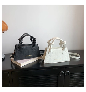 Détail de mini sacs à main gaufrés crocodile avec nœuds décoratifs et logo de mode doré