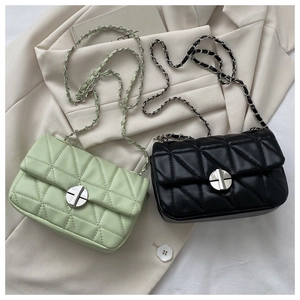 Detail of quilted leather texture and silver chain strap on green and black bags