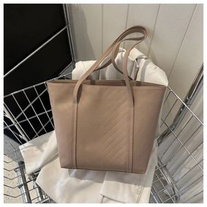 Vista dettagliata della borsa tote beige con cuciture a V e manici lunghi a spalla