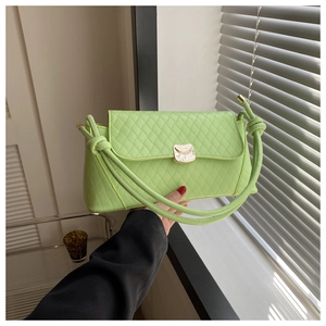 Détail du sac sous le bras matelassé vert citron avec boucle dorée et bandoulière nouée