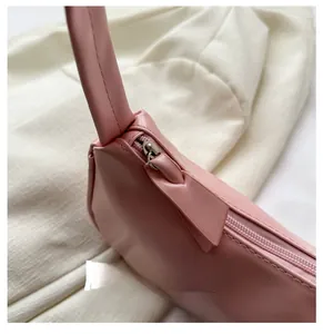 Close-up of smooth silver zipper and pink leather texture on underarm bag