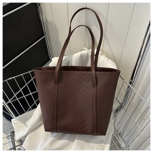 Dettaglio della grande borsa tote marrone scuro con cuciture a V sulla pelle PU