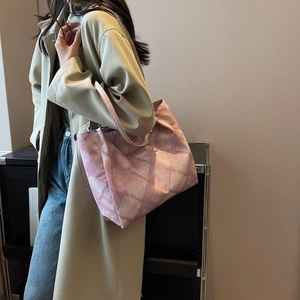 Rosa gesteppte Canvas-Einkaufstasche mit Kettenriemen am Modell für lässigen Urban-Look