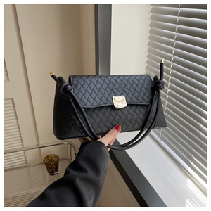 Détail du sac à bandoulière noir à motif losanges avec fermoir métallique doré
