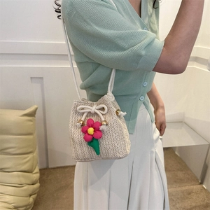 Sweet cream woven straw bucket bag with pink floral pendant and cotton rope strap