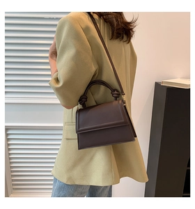 Détail du sac bandoulière marron foncé avec un design de poignée nouée très élégant