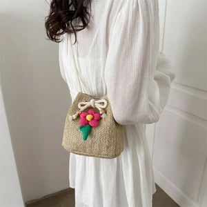 Sweet straw bucket bag with pink flower accent and white drawstring bow for women